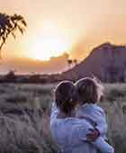 Mother and child watching the sunset on safari in Africa on a family safari